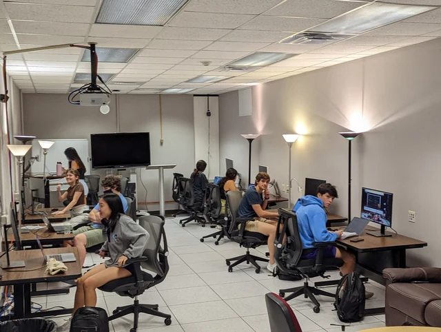 Students work together at shared desks in the early App Lab.